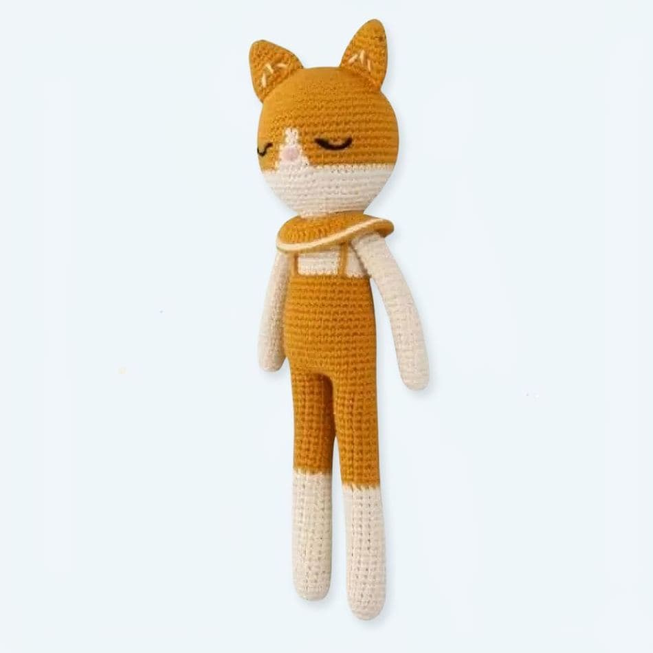 Cozy, handmade knitted plush toys: animals, dolls, characters, displayed in an urban shop. Soft, cuddly, knitted animals, baby gifts, nursery decor.